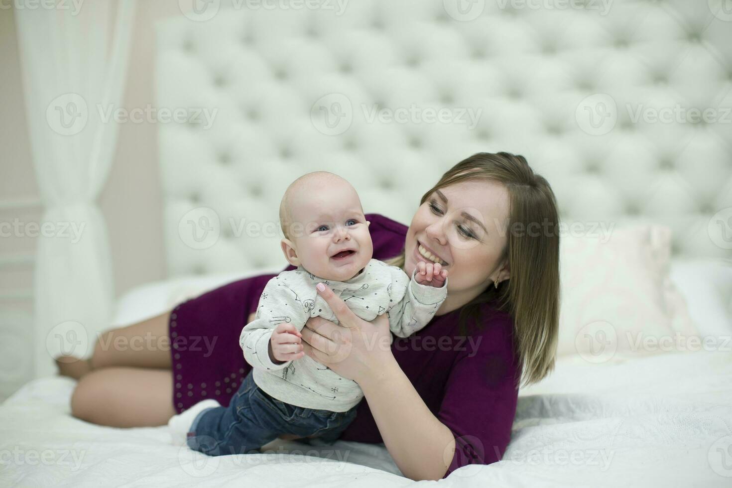 mamma con sua poco figlio su il letto.madre e bambino foto