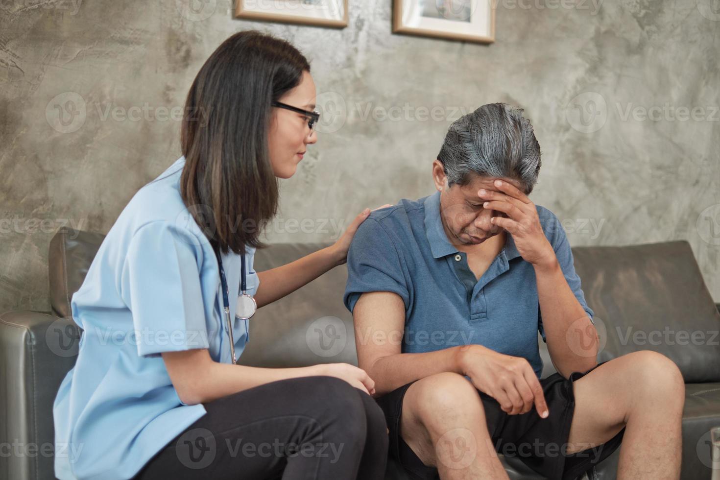 medico femminile che controlla la salute del paziente maschio anziano asiatico a casa. foto