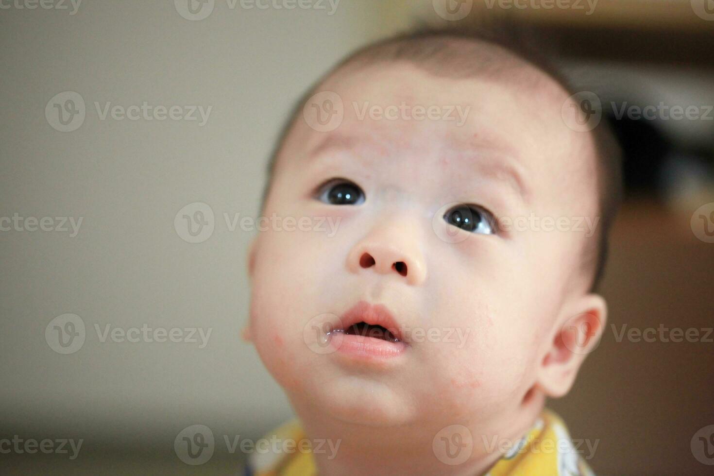 felicità nel innocenza asiatico bambino ragazzo sorrisi su accogliente letto foto