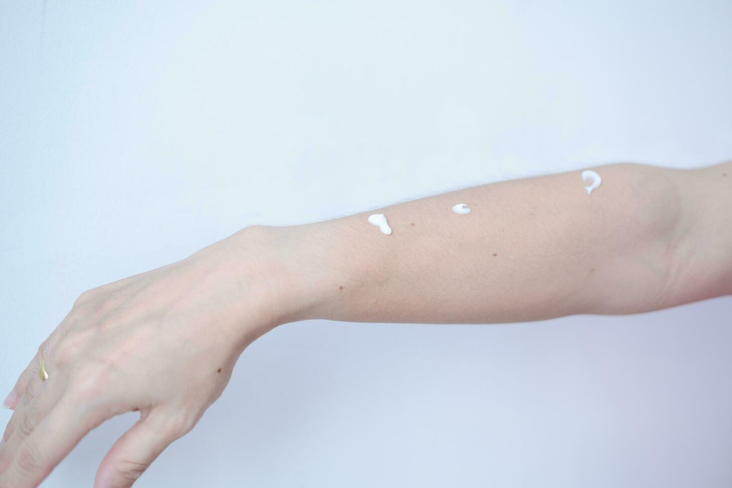 donna di braccio con pelle crema in attesa per pelle cura strofinare foto