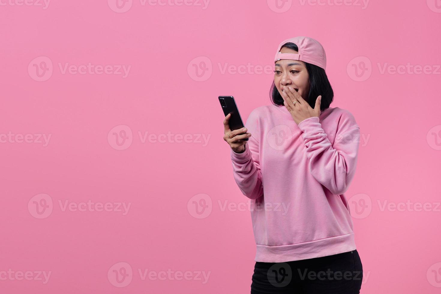 giovane donna asiatica scioccata usando il cellulare foto
