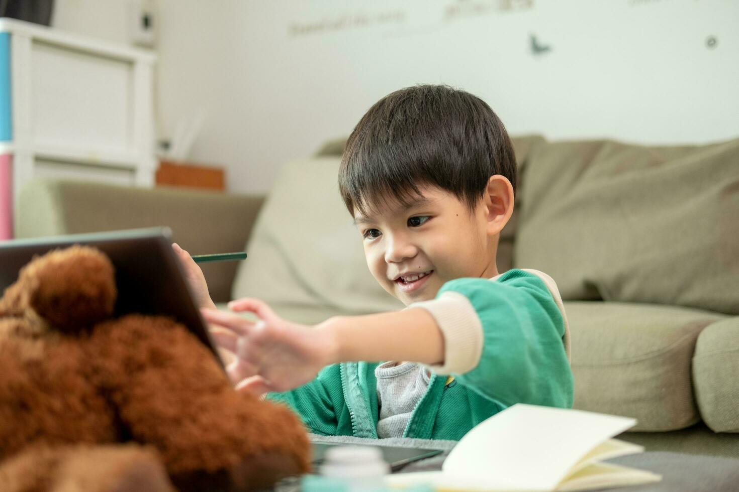 asiatico ragazzo studiando in linea e fare attività su il computer portatile foto