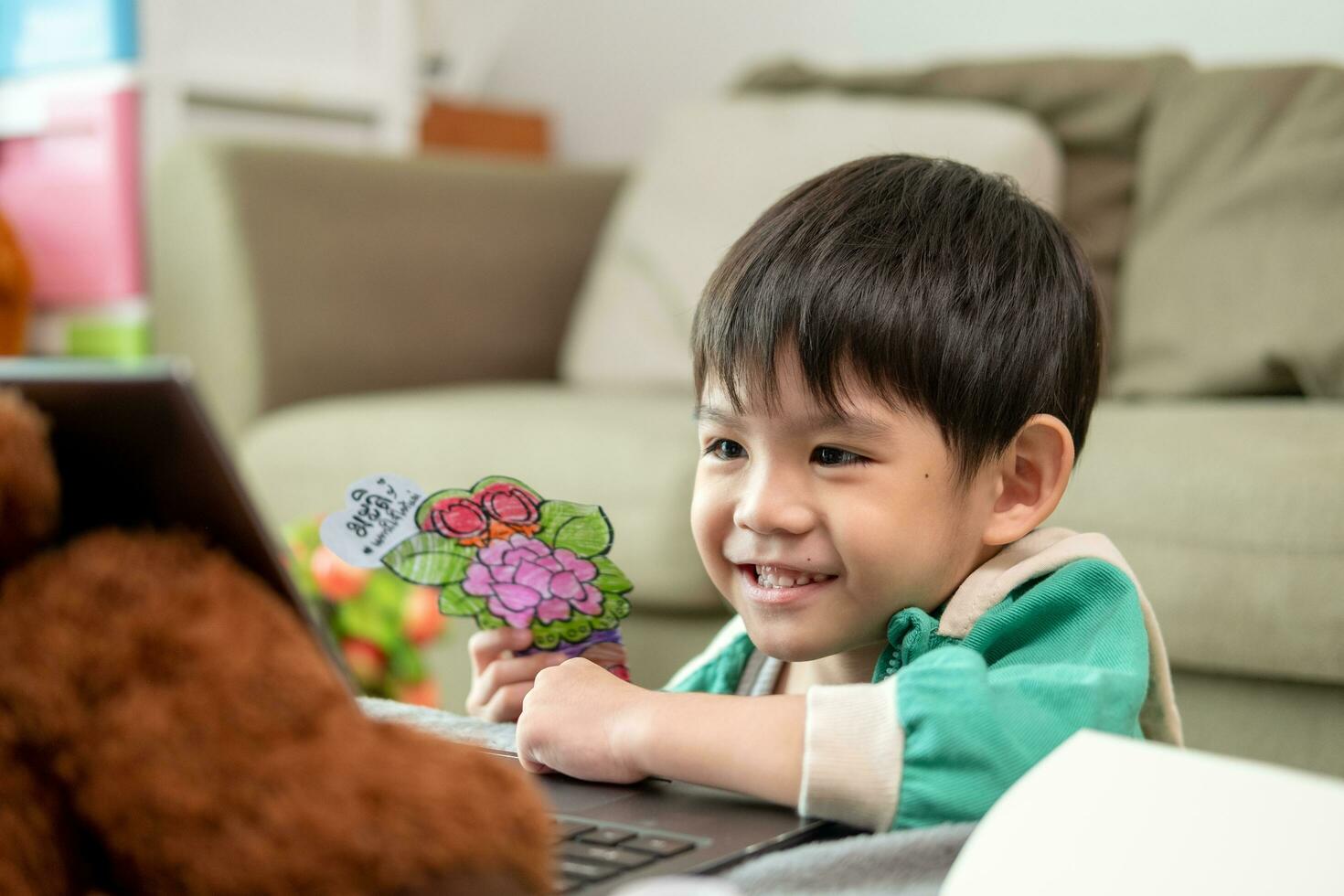 asiatico ragazzo studiando in linea e fare attività su il computer portatile foto