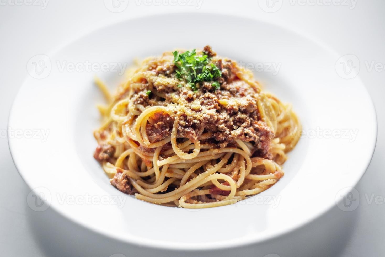 spaghetti alla bolognese con carne di manzo e pomodoro piatto di parmigiano foto