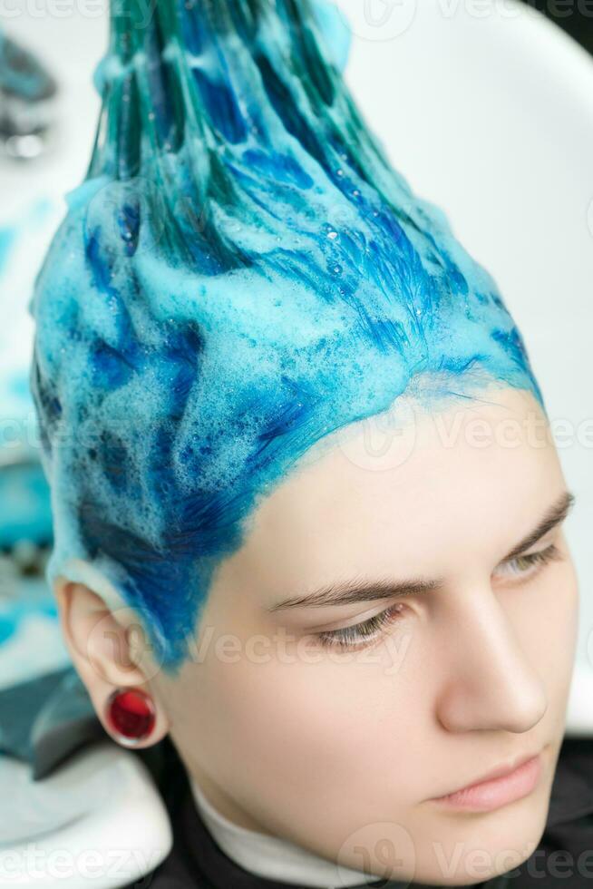 testa di giovane donna con blu capelli mentre lo shampoo testa nel capelli salone dopo tintura foto