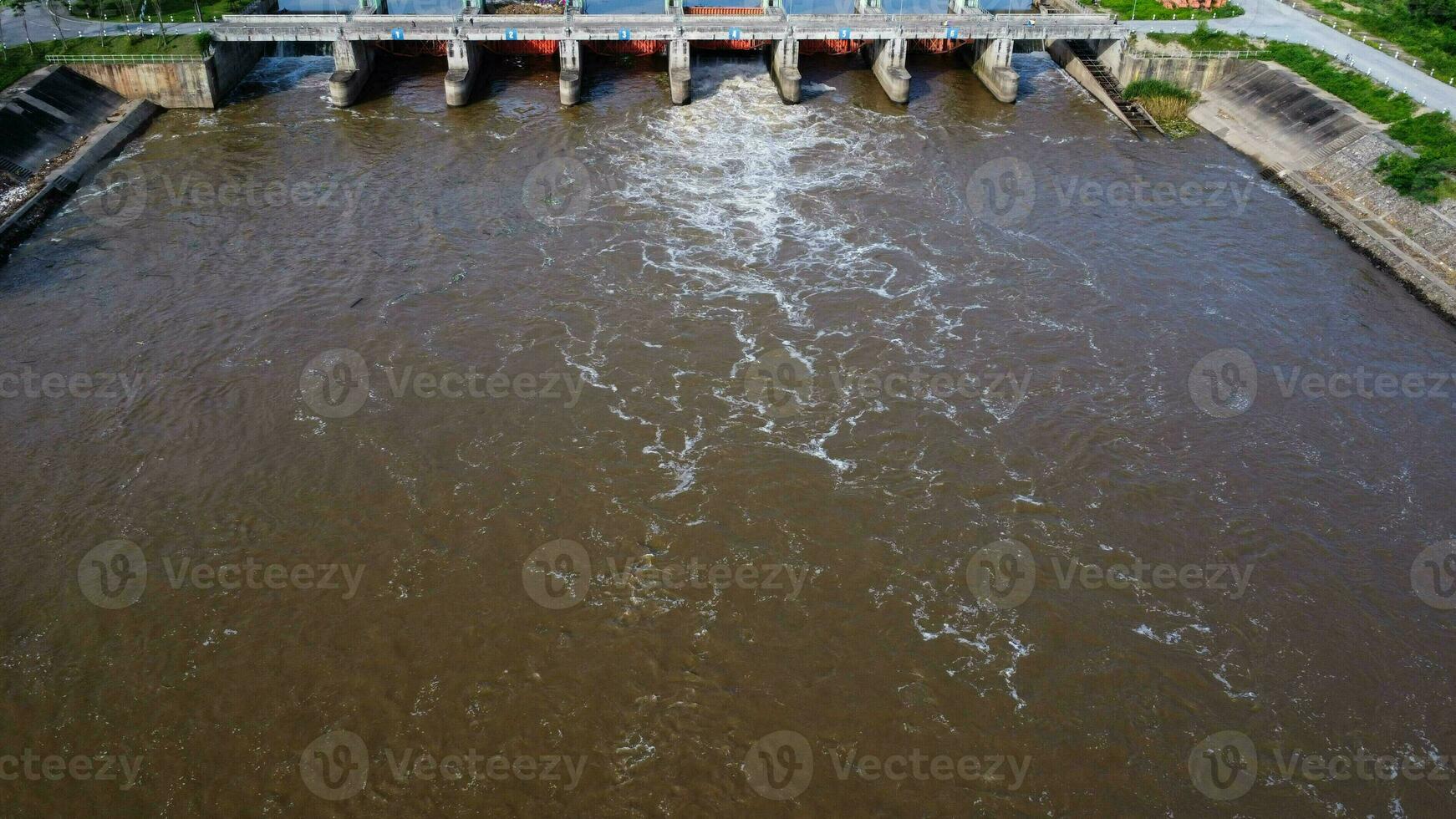 aereo Visualizza di acqua rilasciato a partire dal il drenaggio canale di il calcestruzzo diga è un' modo di traboccante acqua nel il piovoso stagione. superiore Visualizza di torbido Marrone foresta acqua flussi a partire dal un' diga nel Tailandia. foto