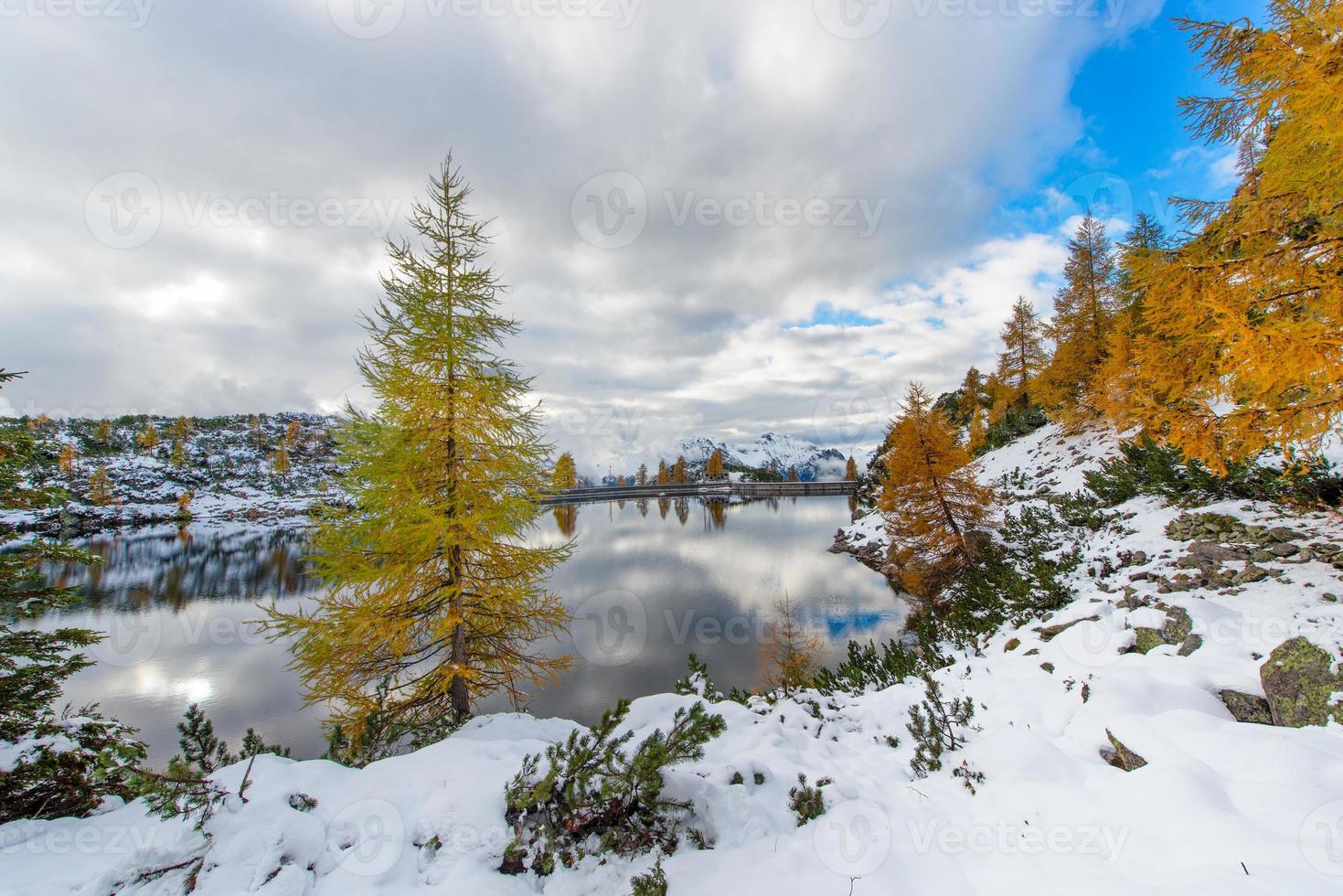 lago alpino in autunno con la prima neve foto