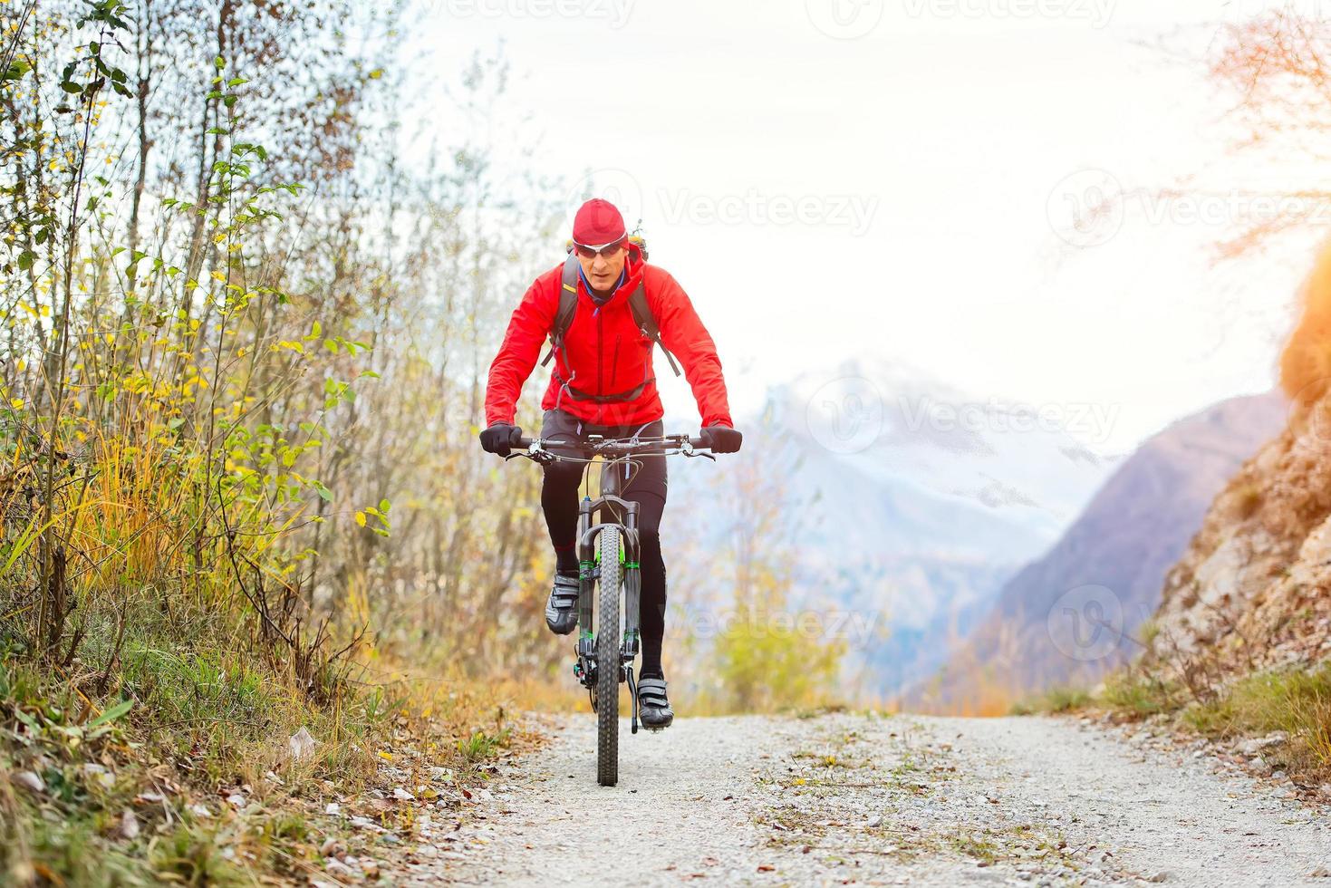 mountain biker su una strada sterrata da solo foto
