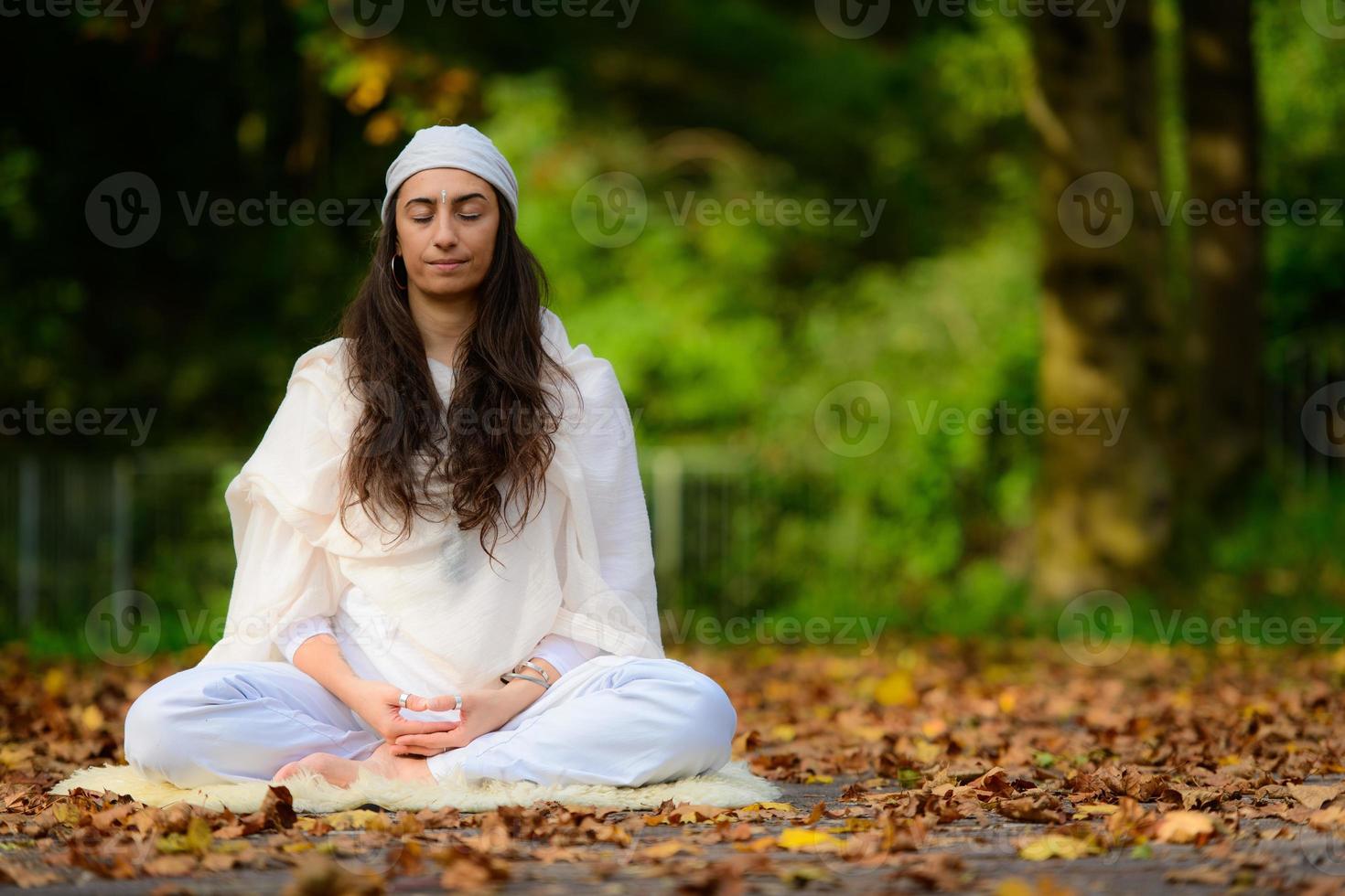 ragazza pratica yoga tra le foglie d'autunno foto