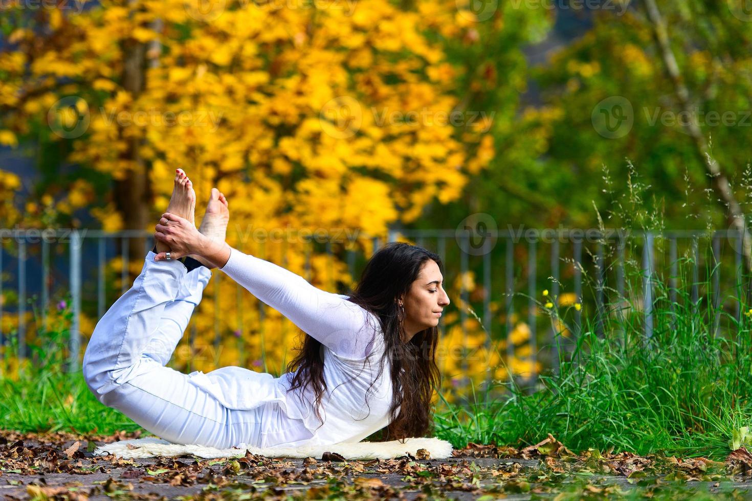 posizione yoga di una giovane donna nel parco in autunno foto