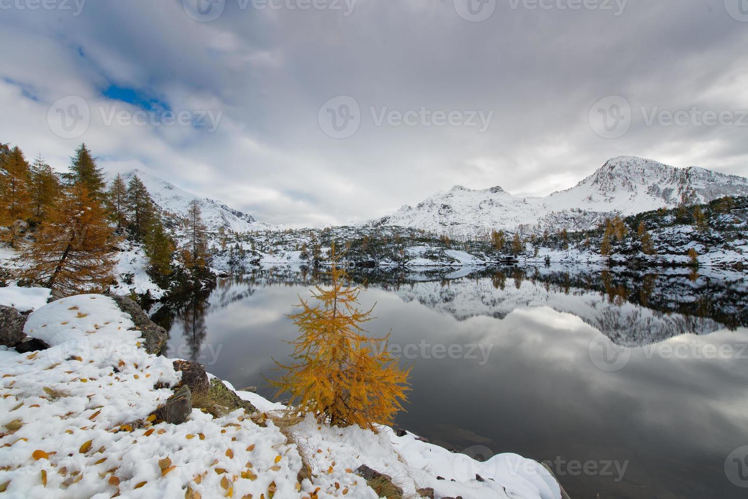 contrasto autunno inverno lago alpino foto