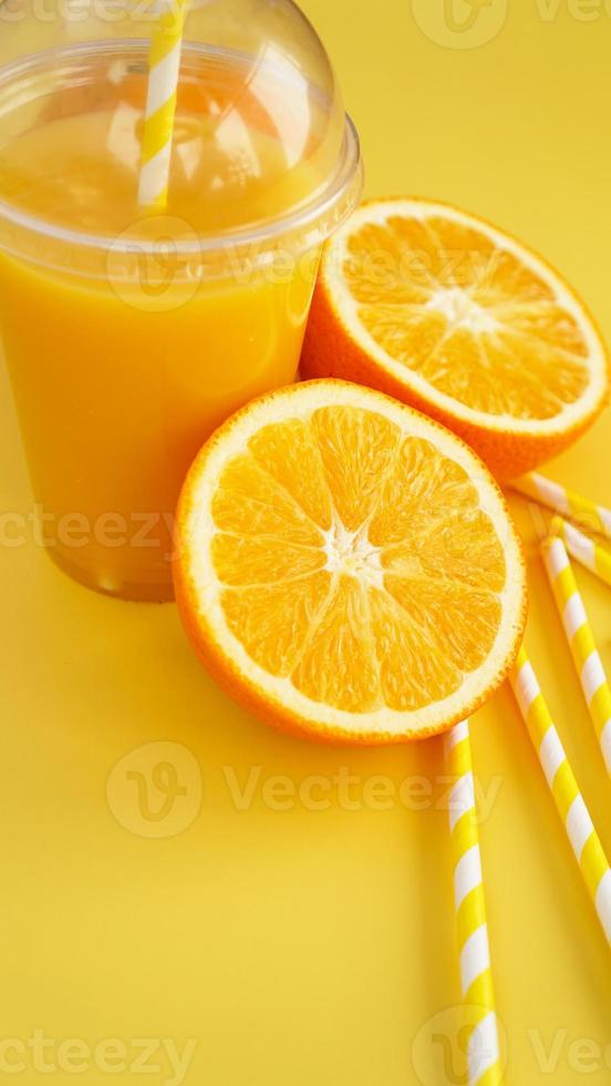 succo d'arancia in fast food tazza chiusa con tubo su sfondo giallo foto
