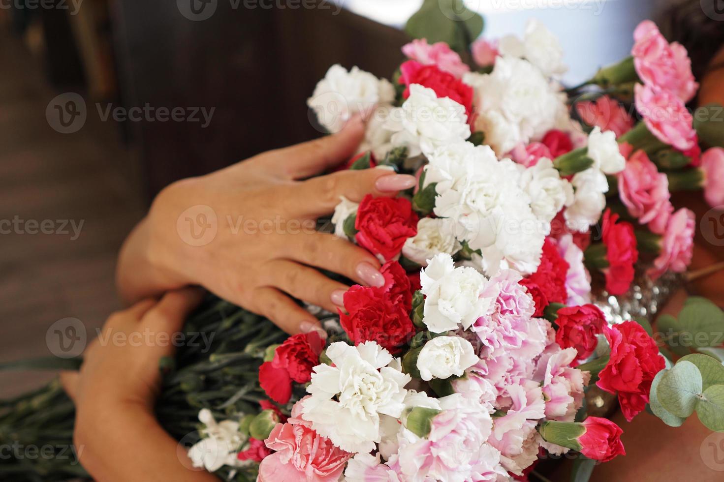 donna che tiene in mano un bellissimo mazzo di fiori colorati in fiore foto