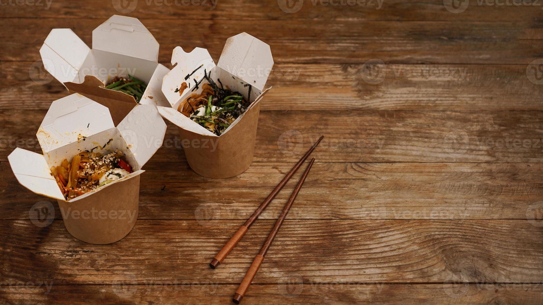 noodles con carne di maiale e verdure in scatola da asporto su tavola di legno foto