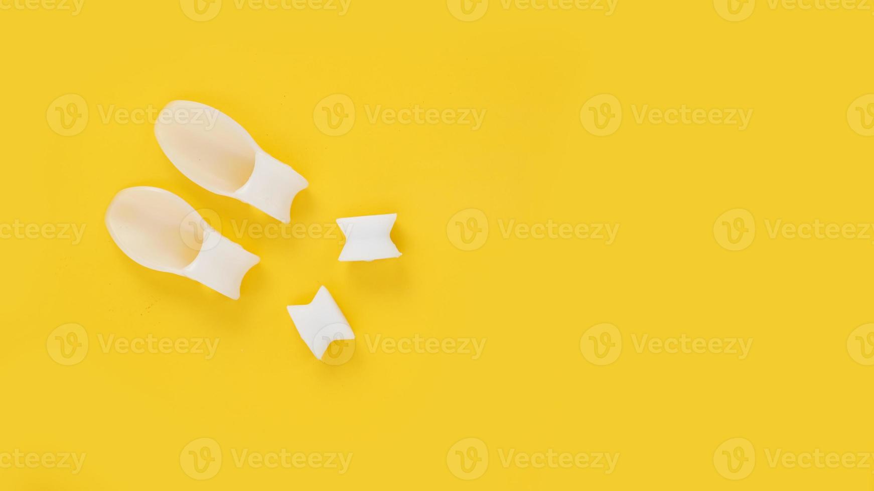 divisore per le dita in silicone bianco su sfondo giallo foto