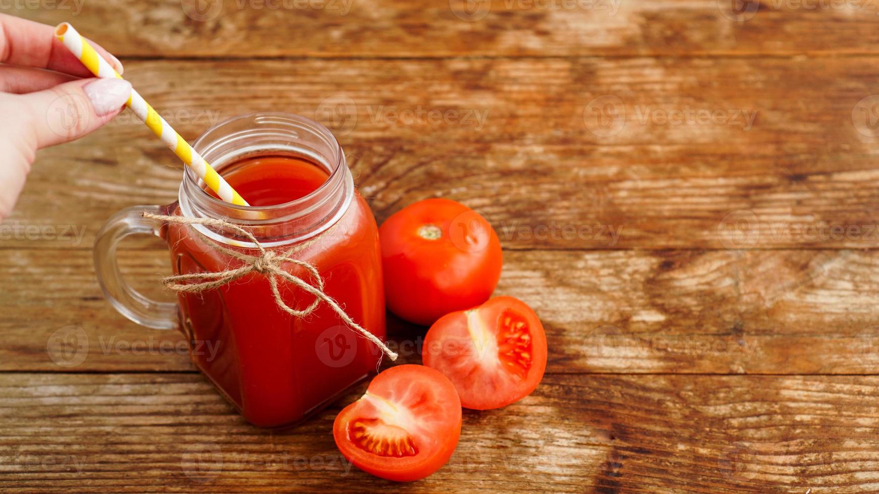 bicchiere di succo di pomodoro sul tavolo di legno. succo di pomodoro fresco foto