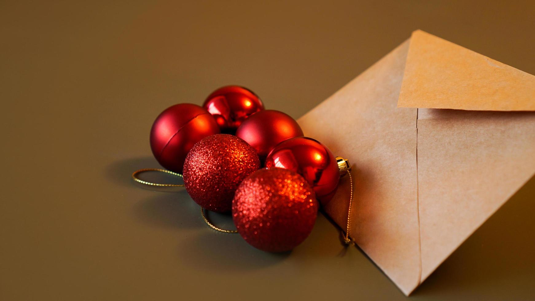 composizione di natale. busta artigianale e palline rosse foto