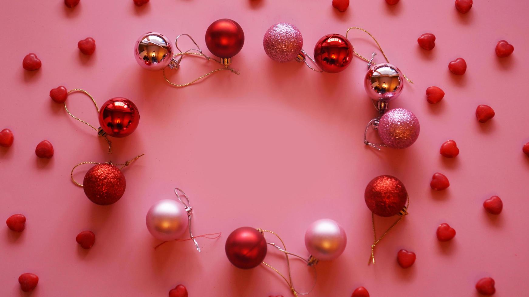 cornice festiva fatta di palle di natale sul tavolo rosa vista dall'alto foto