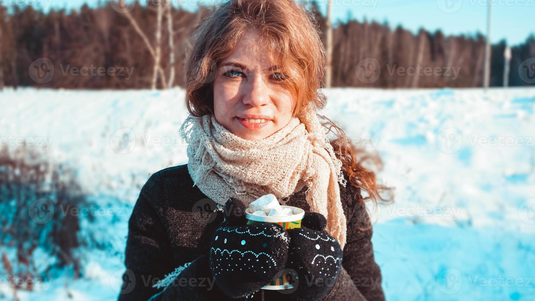 bella giovane donna che tiene tazza di caffè con marshmallow foto