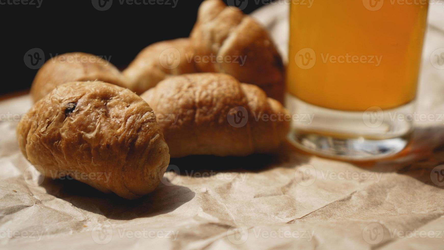 croissant appena sfornati con succo d'arancia su carta kraft foto