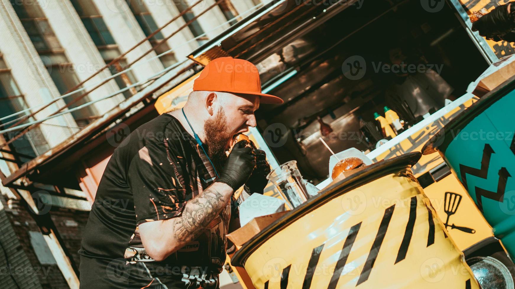 l'uomo si gode il festival del cibo di strada all'aperto, l'evento di birra e hamburger foto