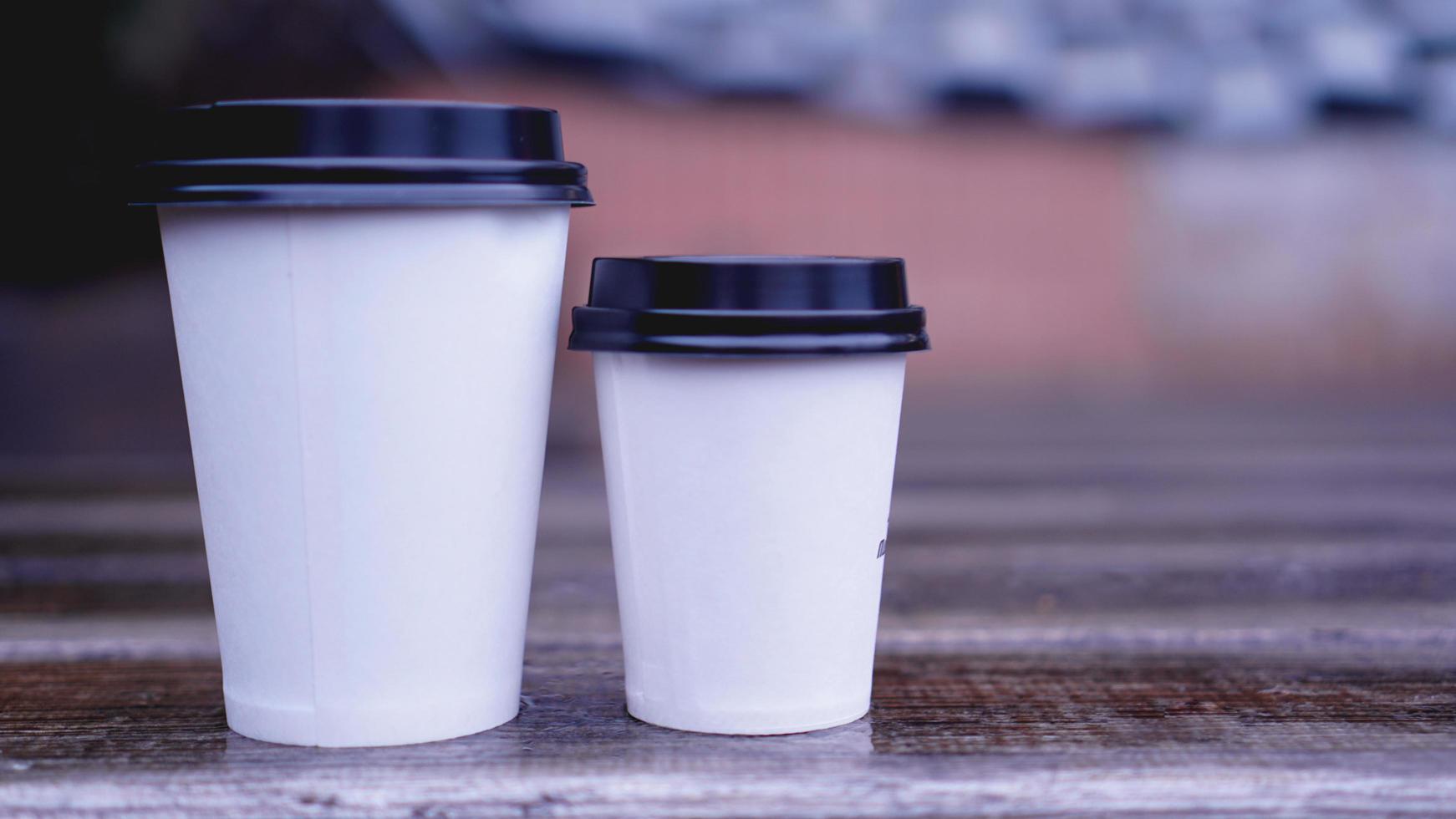 la tazza di caffè artigianale in carta si trova su una superficie di legno foto