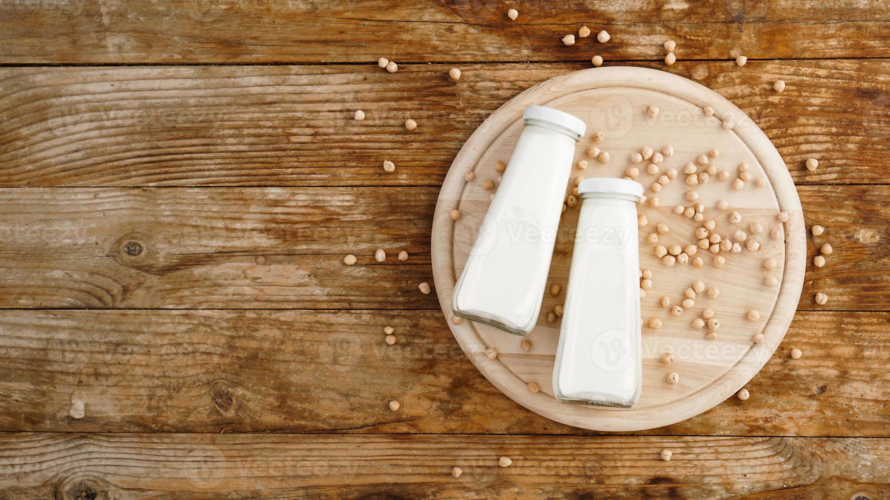 latte di soia e fagiolo di soia su fondo di legno, concetto sano. foto