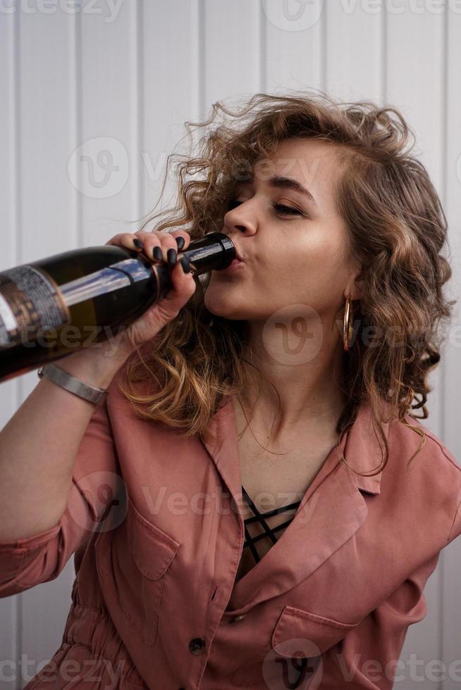 ritratto di felice affascinante giovane donna con bottiglia di champagne foto