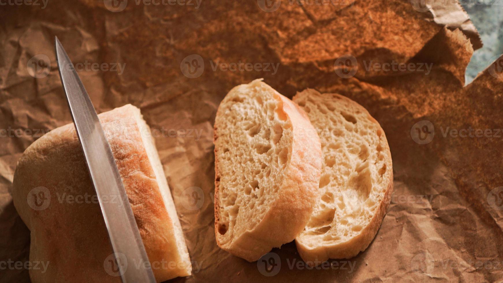 lo chef affetta la ciabatta con un coltello. Ciabatta foto