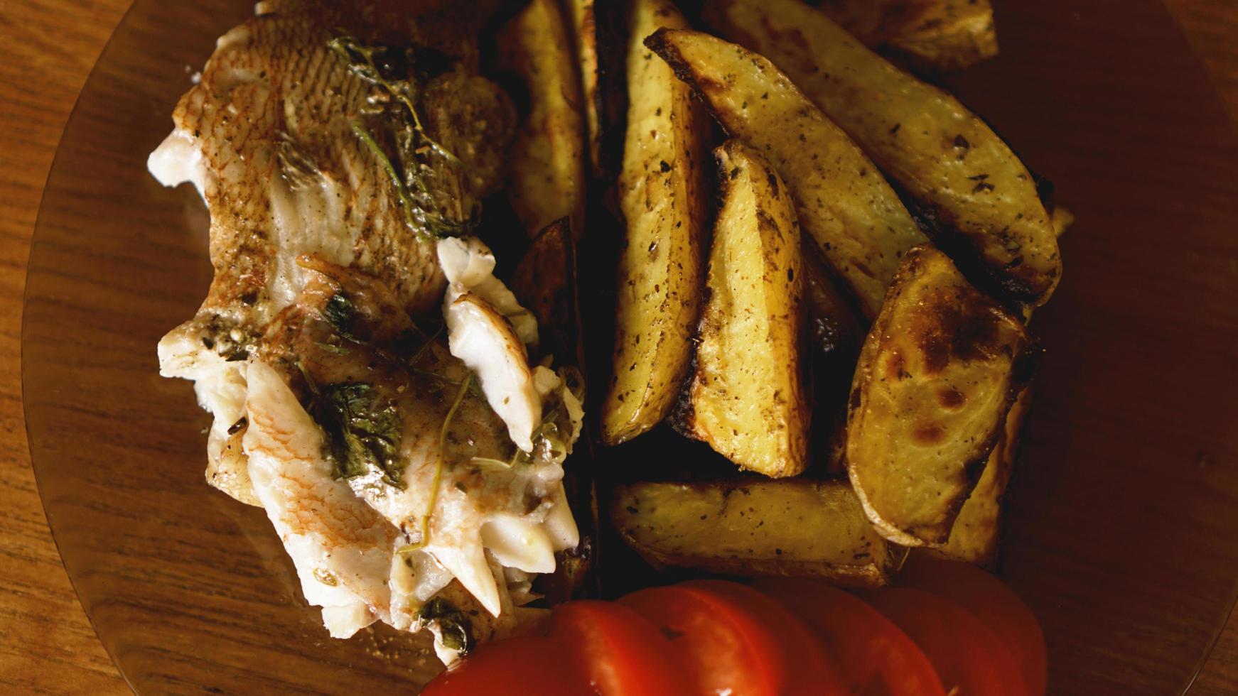 piatto di pesce - filetto di pesce fritto con patate fritte e verdure foto