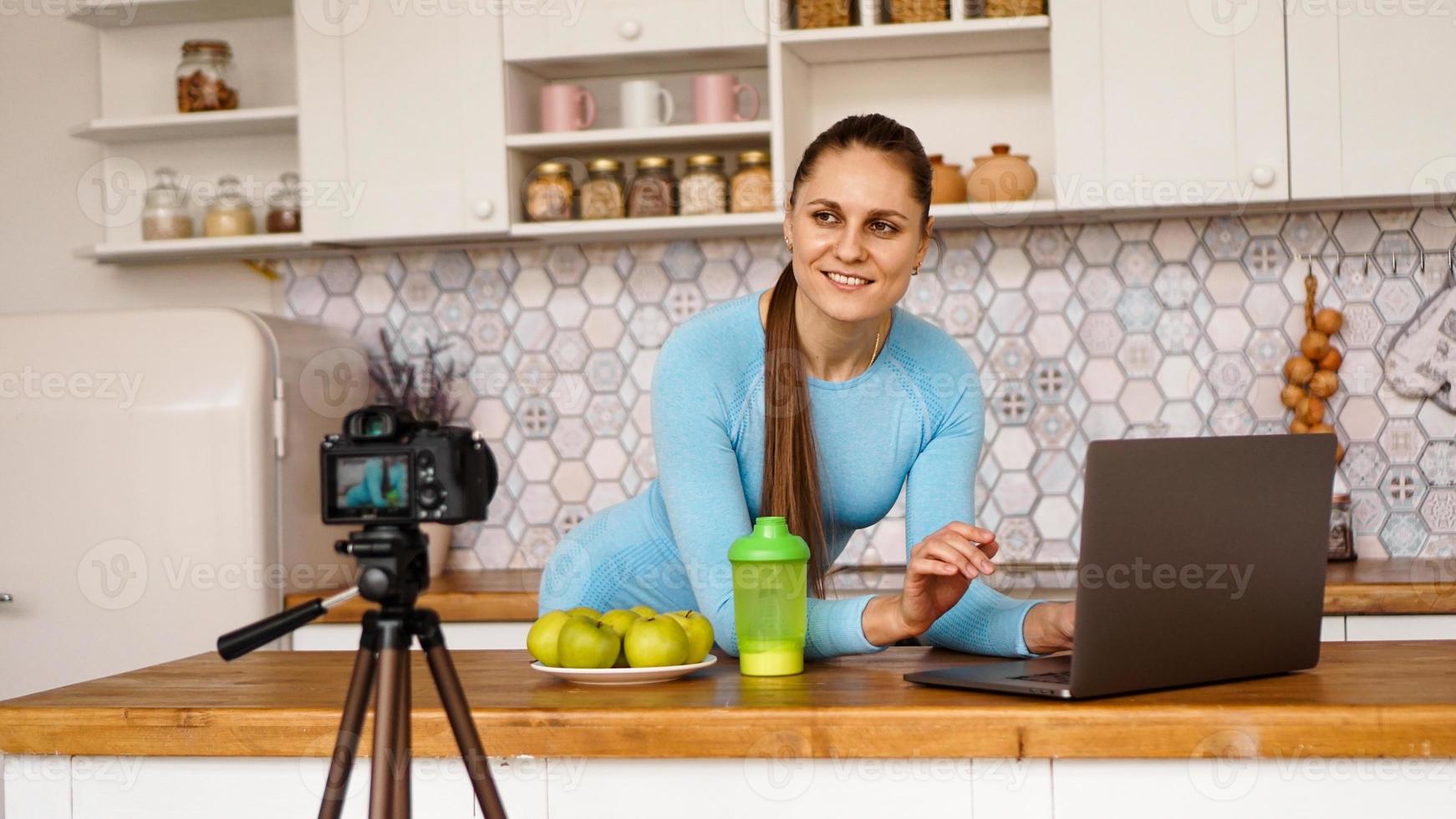 donna in cucina con il laptop alla ricerca di ricette foto