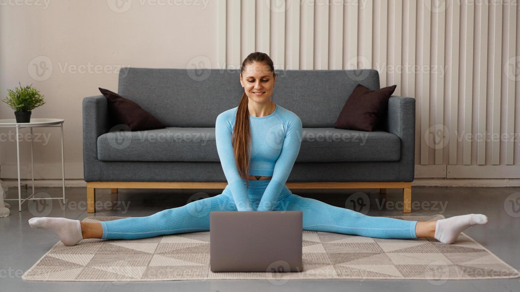 una bella donna con una tuta blu si sta allungando foto