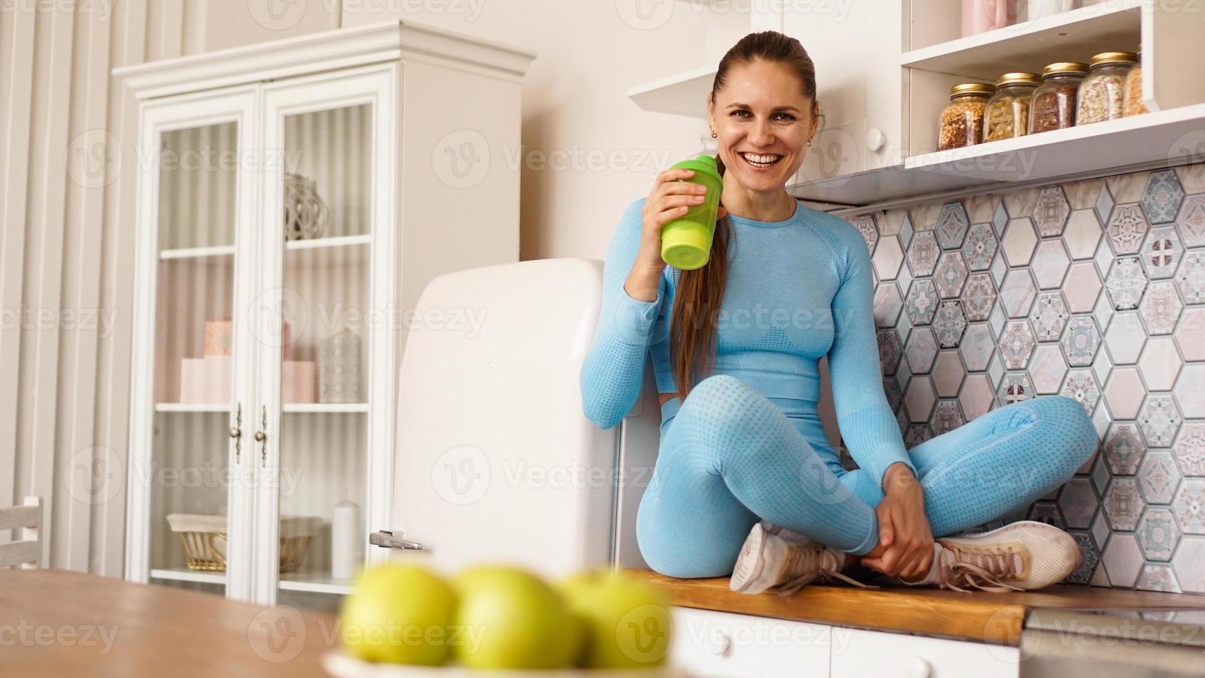 la donna si siede sul piano di lavoro in cucina foto