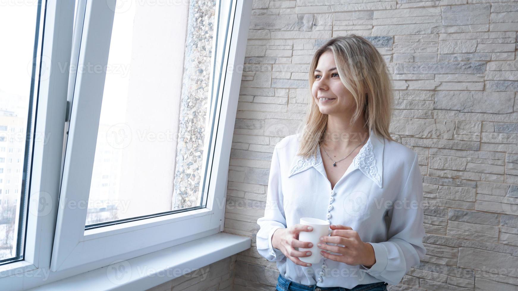 donna d'affari che guarda fuori dalla finestra foto