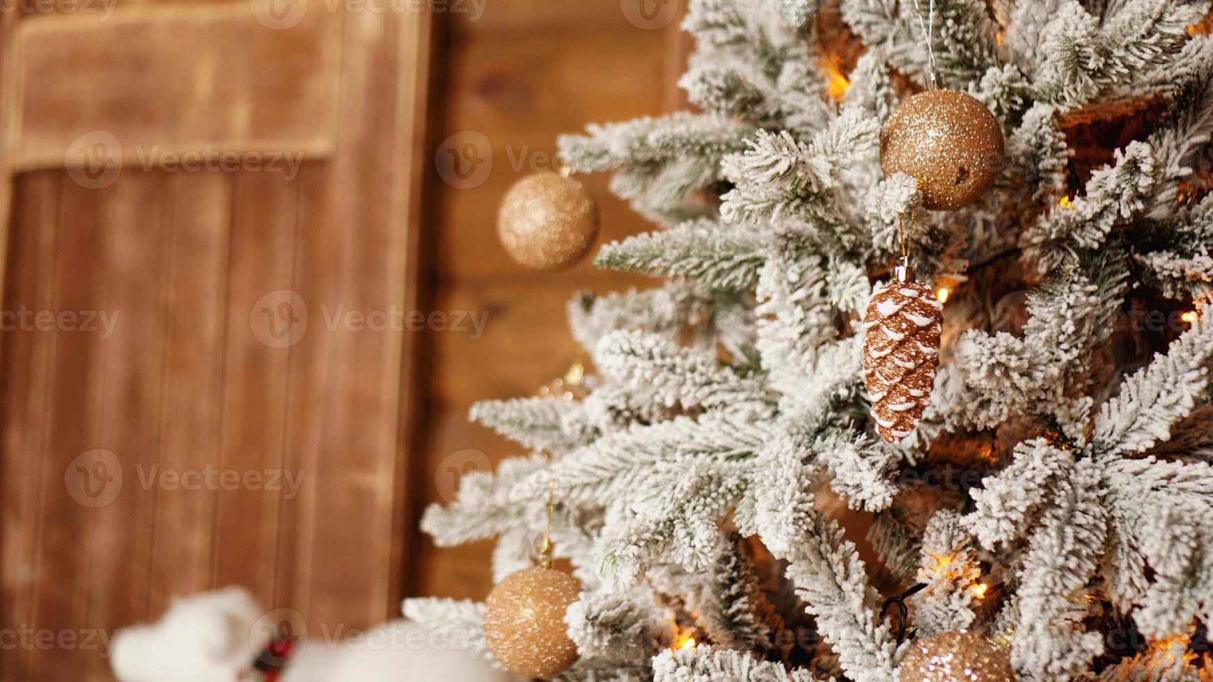 albero di natale d'argento con palline dorate su fondo in legno foto