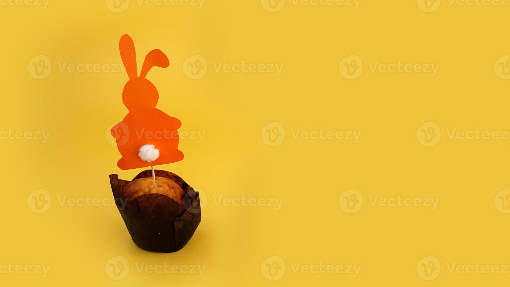 muffin decorati con un coniglio di carta su uno stuzzicadenti foto