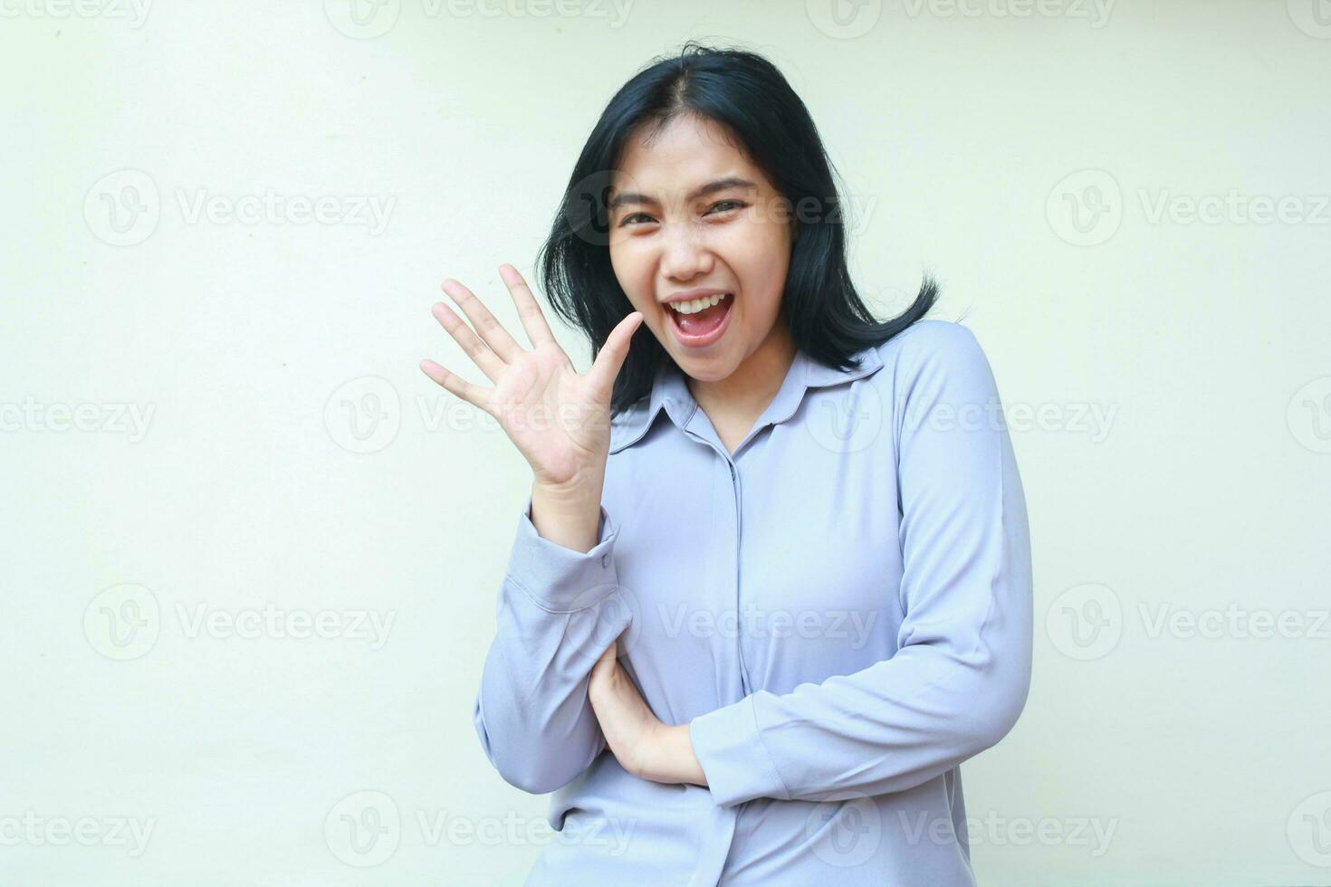 bellissimo amichevole asiatico giovane attività commerciale donna eccitato per dire Ciao per telecamera con sorridente viso, agitando mano con piegato braccio, indossare formale camicia isolato nel bianca sfondo foto