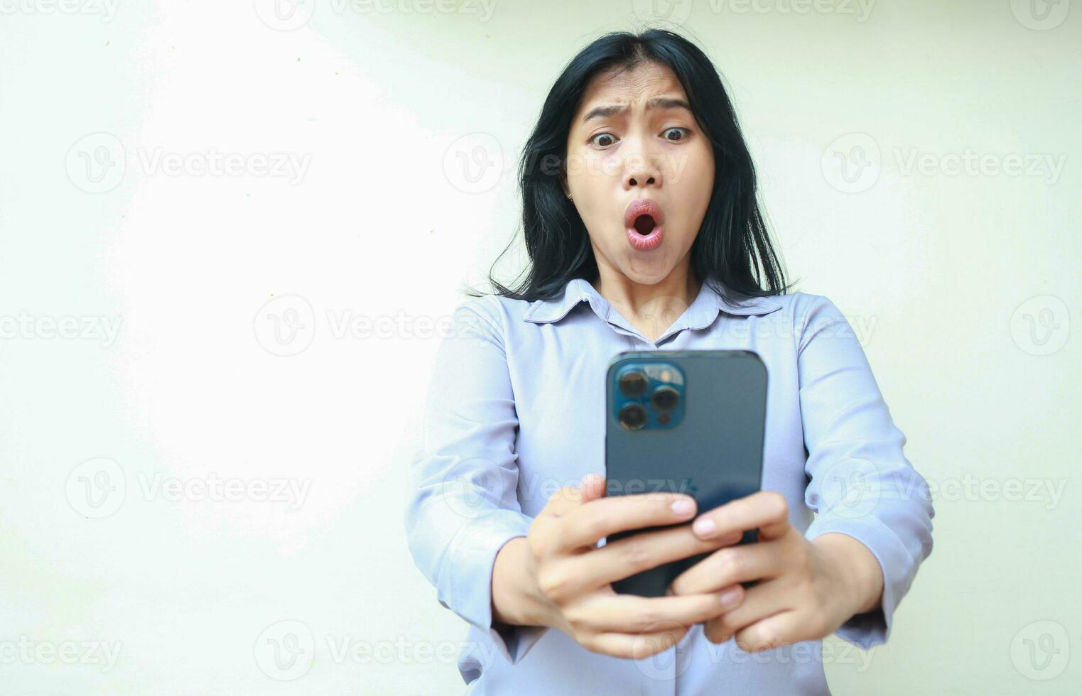 stupito asiatico giovane attività commerciale donna utilizzando smartphone scioccato con Wow espressione indossare formale camicia in piedi al di sopra di isolato bianca sfondo foto