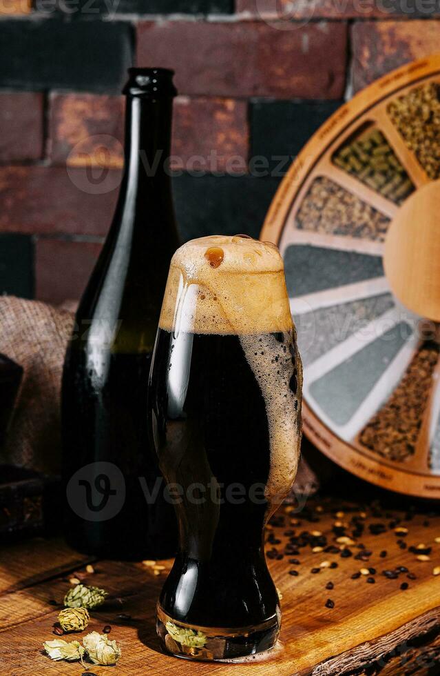 bicchiere di buio birra e bottiglia su di legno foto