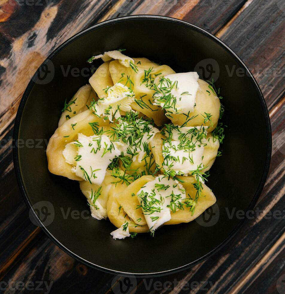 piatto di gustoso cucinato Ravioli su nero piatto foto