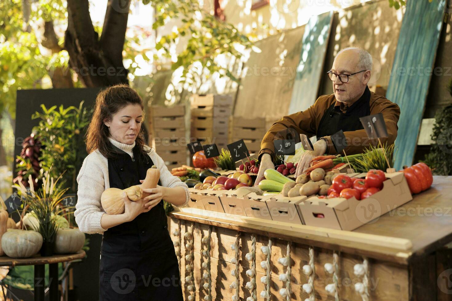 Locale In piedi fornitori di partenza il giorno con fresco naturale produrre, Lavorando a mercato stalla per vendere salutare prodotti. giovane donna mettendo frutta e verdure su agricoltori mercato. foto