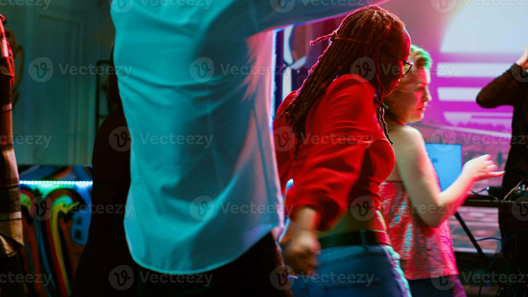 multietnico gruppo di persone danza nel discoteca, avendo divertimento insieme con elettronico musica su danza pavimento. folla di amici salto e partying a discoteca, discoteca faretti. foto