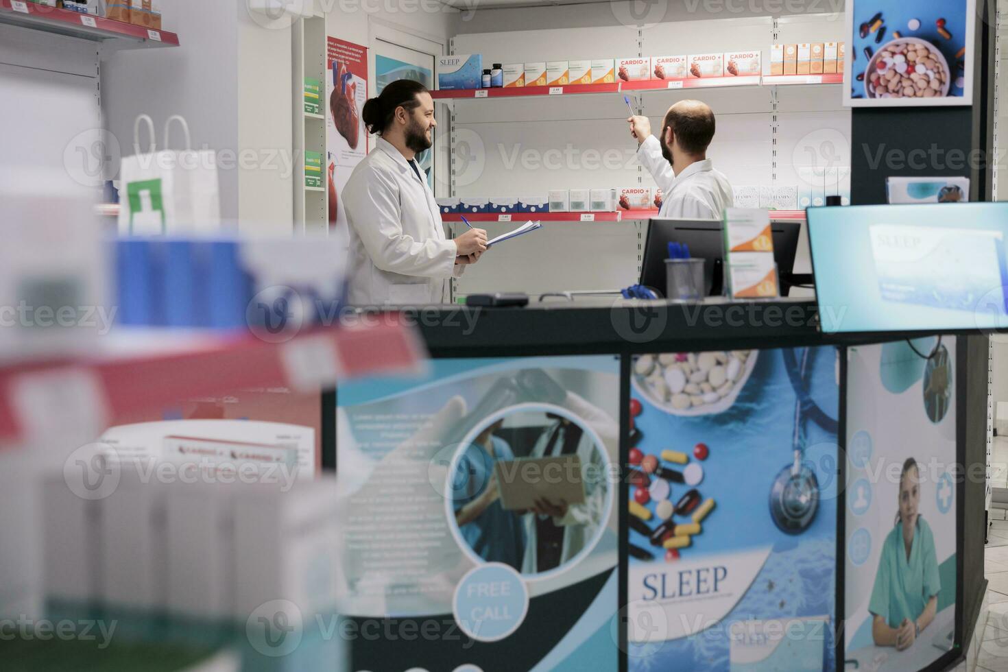 farmacia lavoratori guardare a farmaci pacchi mentre Lavorando a pillole inventario nel farmacia. farmacisti è allenato nel farmacologia e è in grado per riempire e dispense prescrizione medicazione con precisione. foto