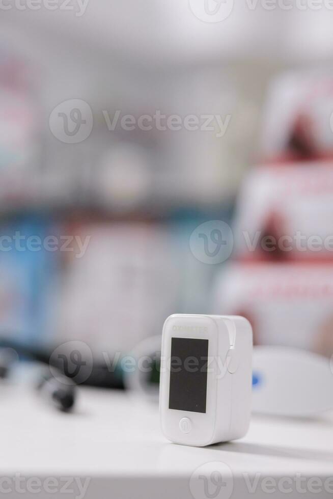 medico ossimetro in piedi su tavolo nel vuoto farmacia pronto per essere Usato di cliente, digitale dispositivo per misurare ossigeno saturazione. farmacia pieno con droghe, vitamine e farmaceutico prodotti foto