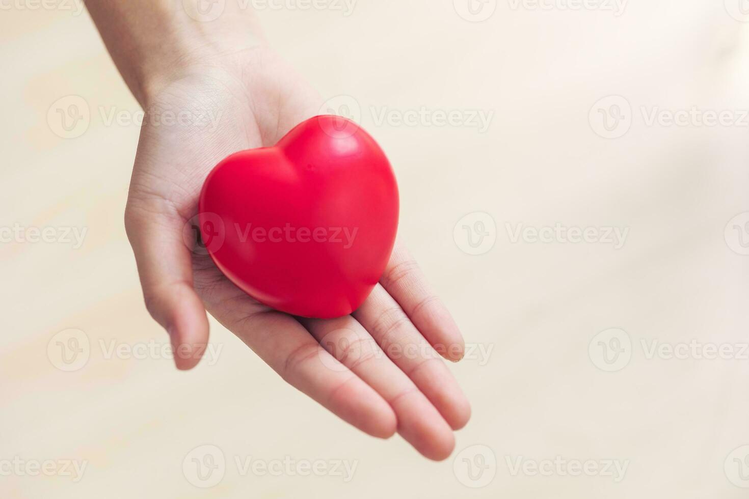 rosso cuore amore cartello nel medico mano esercizio palla con copia spazio per mondo cuore Salute giorno, mondo ipertensione cuore attacco giorno. foto