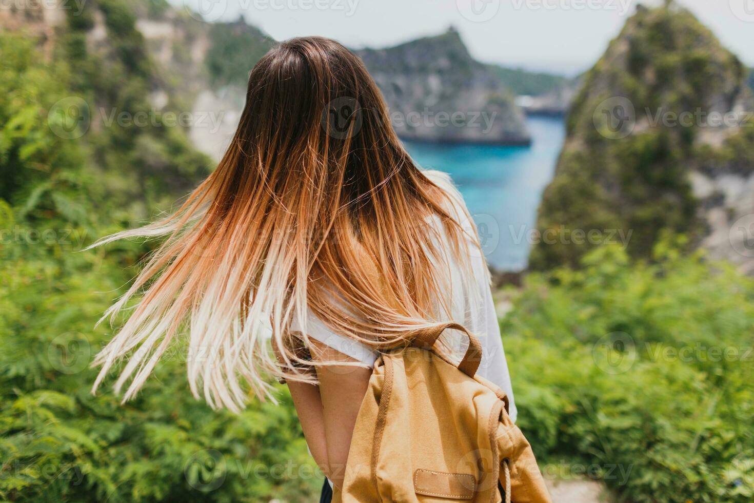 indietro Visualizza di in viaggio donna su scogliere e tropicale spiaggia sfondo. la libertà e avventura concetto. vicino su . Indonesia, nusa penida isola. foto