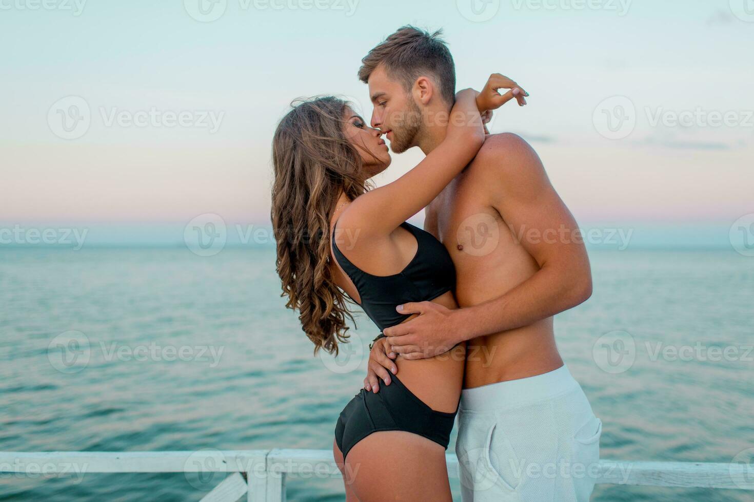 all'aperto vicino su moda ritratto di bella sexy coppia nel amore abbracci su sorprendente tropicale spiaggia, indossare elegante costumi da bagno. foto