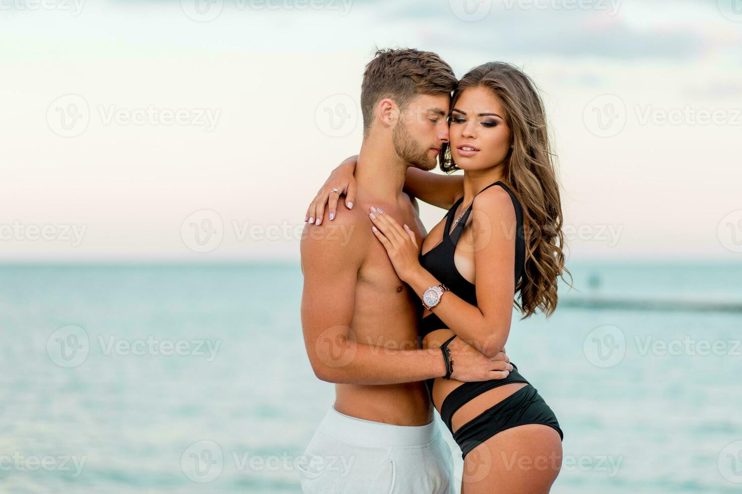 all'aperto vicino su moda ritratto di bella sexy coppia nel amore abbracci su sorprendente tropicale spiaggia, indossare elegante costumi da bagno. foto