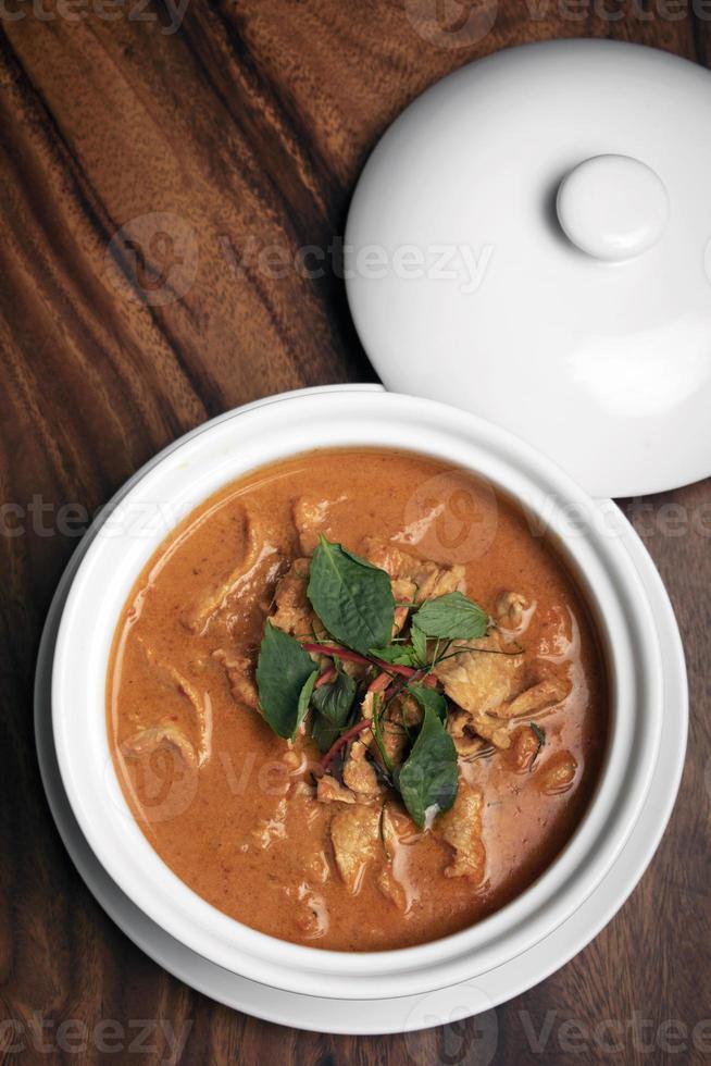 curry di maiale panang piccante tailandese con latte di cocco sulla tavola di legno a phuket thailand foto