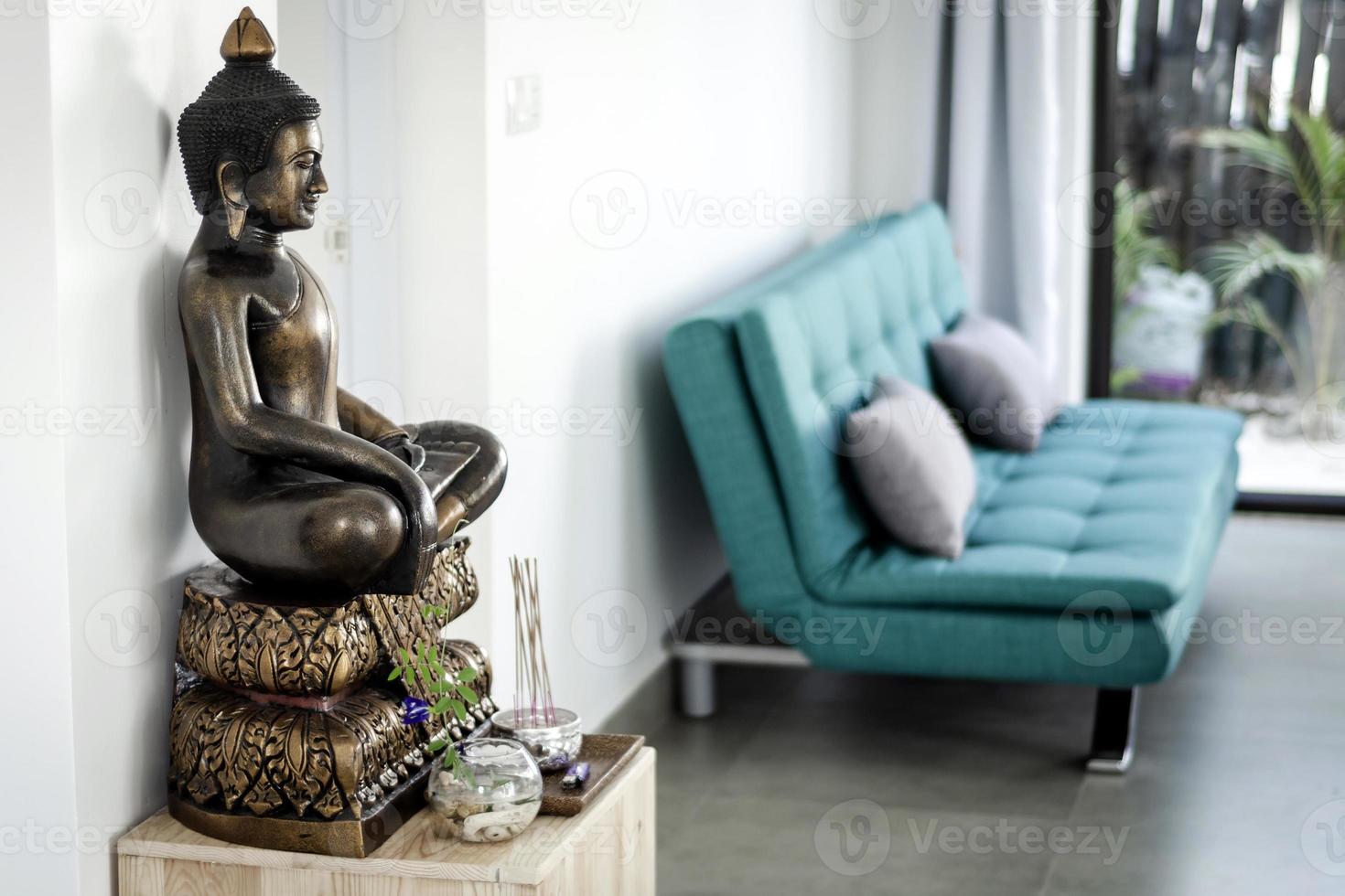 dettaglio di interior design della statua di Buddha in bronzo nel soggiorno di una casa asiatica moderna foto